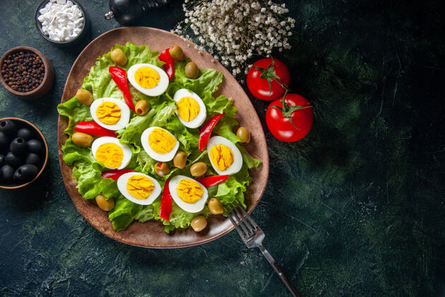 绿色俯视图美味的鸡蛋沙拉由橄榄和绿色沙拉组成 背景为深色午餐晚餐番茄