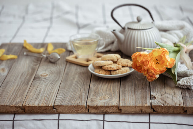 花一杯茶 一个茶壶 饼干和一束郁金香早上茶壶早餐