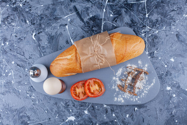 烘焙面包 蔬菜片 煮鸡蛋放在蓝色的船上美味面团板