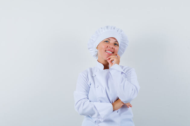 欢乐穿着白色制服的女厨师站在思考的姿势里 看上去很高兴现代时尚女人