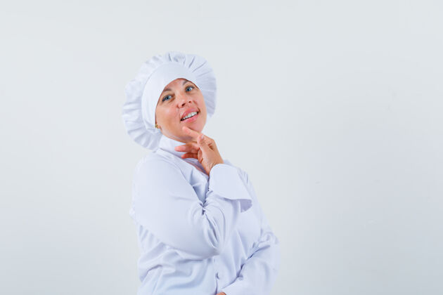 可爱穿着白色制服的女厨师用手指抚摸下巴 看上去很迷人厨师现代女人