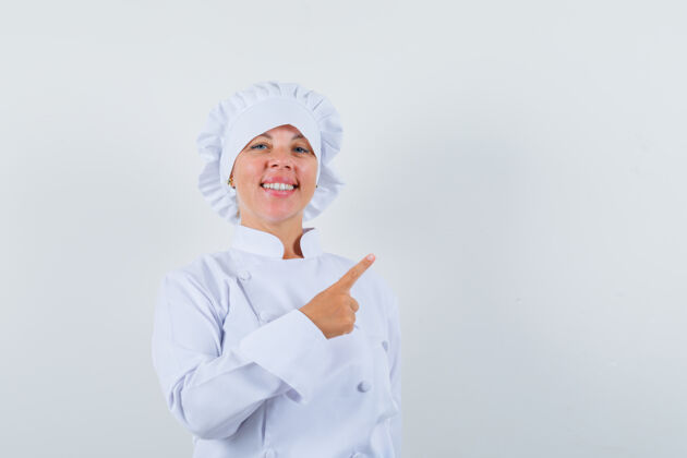时尚身着白色制服的女厨师指着右上角 看上去很自信角落模型女人