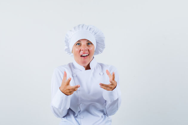 肖像一位身穿白色制服的女厨师举手 看上去很兴奋女士卷发可爱