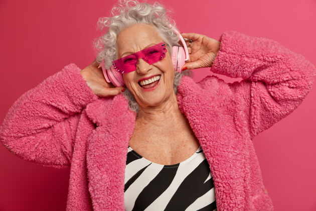太阳镜穿着粉色紧身衣和外套 满脸皱纹的时尚老奶奶的特写照片放松微笑技术
