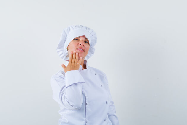 制服一位身穿白色制服的女厨师用手指托着下巴 看上去很精致魅力女人下巴
