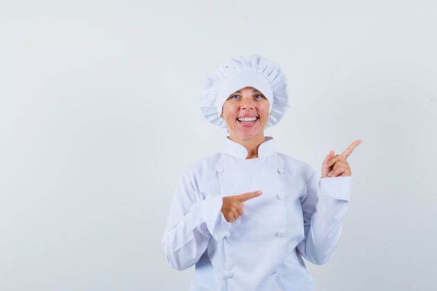 快乐一位身穿白色制服的女厨师指着右上角 看上去很快乐指向女士年轻