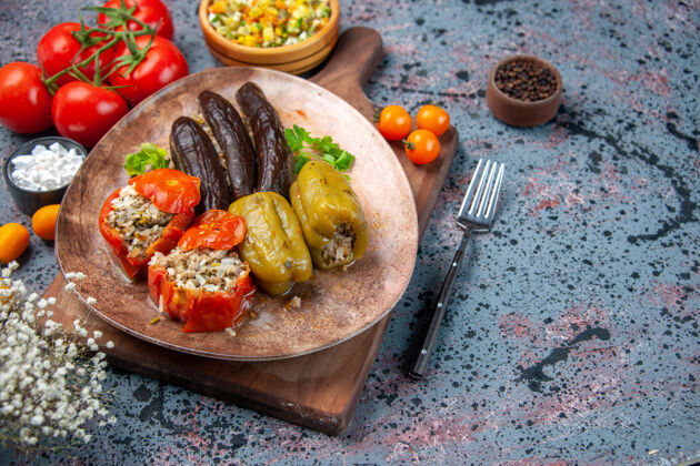 胡椒前视图美味蔬菜多尔玛沙拉和番茄蓝色背景前面背景食物