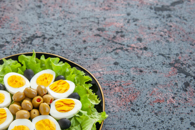 晚餐正面图美味的鸡蛋沙拉由绿色沙拉和橄榄组成背景一致性前面