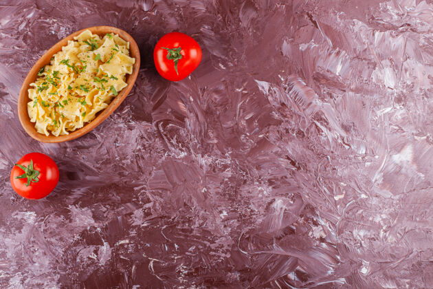 烹饪在一张浅色的桌子上放上两个新鲜的红色西红柿的潘恩意大利面晚餐食物咸味