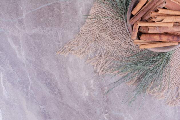 橡树肉桂棒在一个木杯和橡树枝周围冬青节日香料