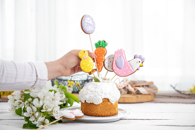 鲜花用姜饼和鲜花装饰节日蛋糕的过程准备复活节假期的概念节日餐桌构图