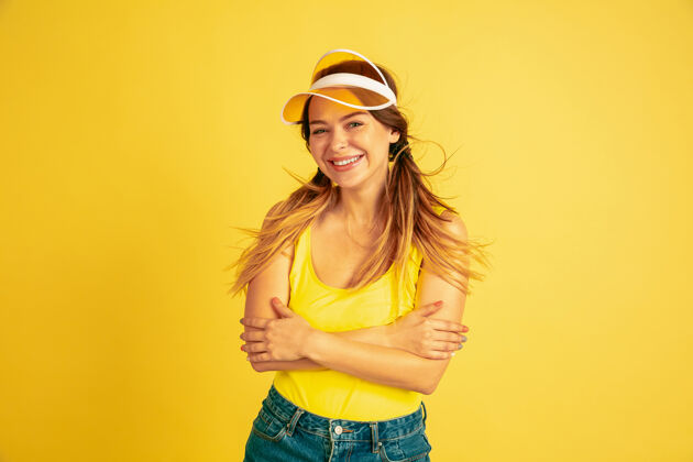 模特摆出可爱 微笑的姿势黄色工作室里的白种女人肖像手事业夏天