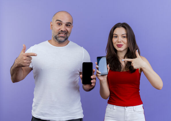 手机自信的成年夫妇拿出手机指着他们秀演示男人