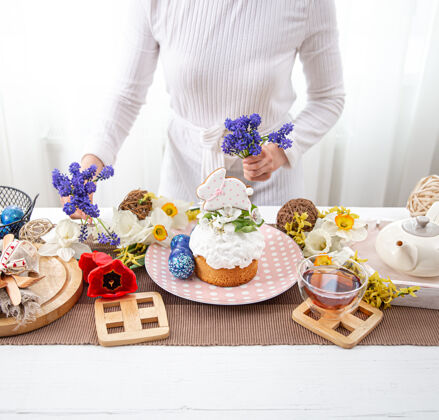 复活节一个女人用鲜花装饰一张桌子复活节的概念装饰茶花