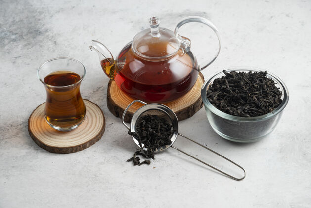花卉在木板上放着茶的玻璃茶壶芳香疗法美味美味