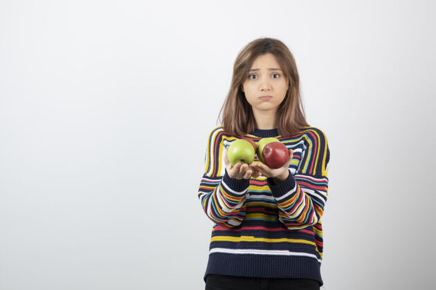 健康可爱的年轻女子 穿着休闲服 手里拿着五颜六色的苹果年轻女性水果