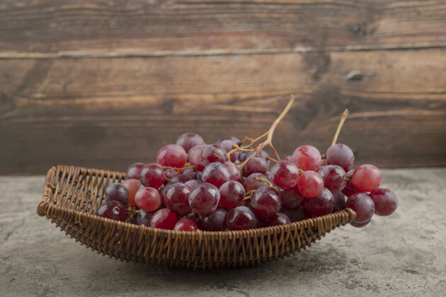 成熟柳条篮美味的红葡萄放在大理石桌上天然健康营养