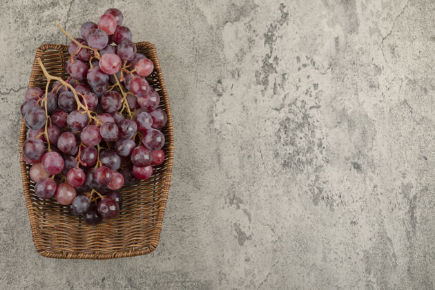 成熟柳条篮美味的红葡萄放在大理石桌上收获水果有机