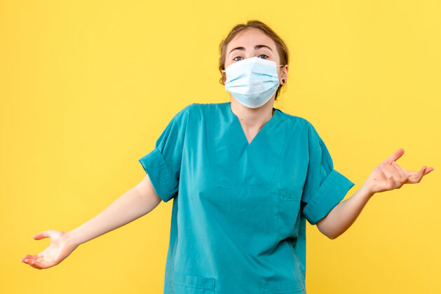 微笑正面图女医生戴着无菌口罩在黄色背景上大流行病毒冠状病毒健康护目镜大流行成人