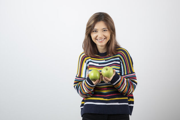 女人一个穿着休闲装的年轻女子 手里拿着青苹果 面带微笑肖像绿色抱