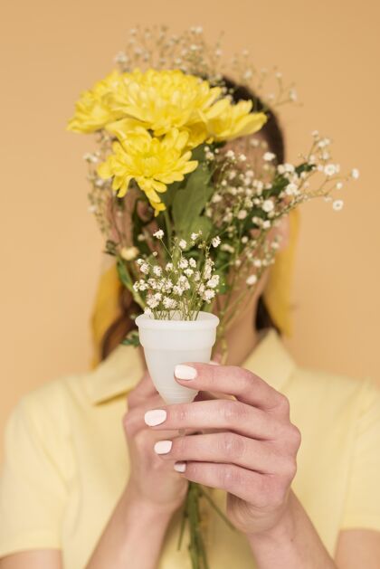 回收用塑料杯里的花遮住脸的女人女人再利用零浪费