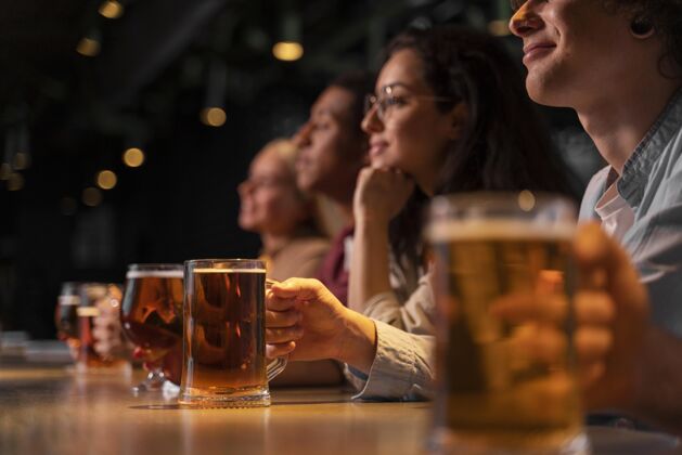 休闲近距离的朋友拿着啤酒杯朋友享受酒吧