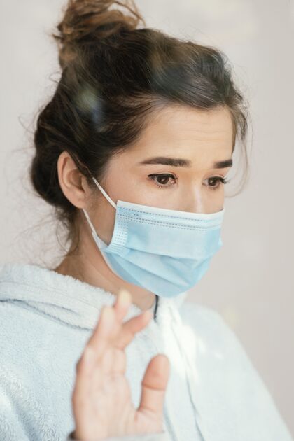 疾病特写戴面具的女人呆在家里流行病冠状病毒