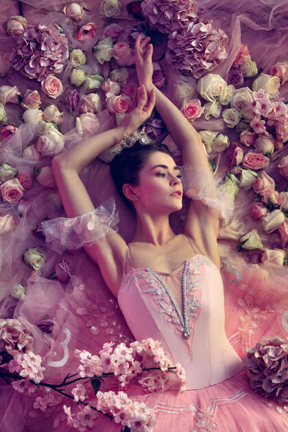 戏剧情感美丽的年轻女子在粉红色芭蕾舞团芭蕾舞团俯视图被鲜花包围春天的心情和珊瑚光温柔春天的概念 开花和自然的觉醒模特现代活跃