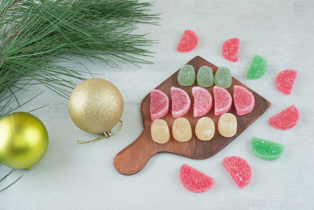 甜木板上满是糖果酱和圣诞球 白色背景高质量的照片糖果美味可食用