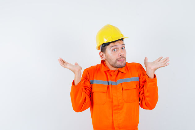 工程建筑工人在制服上表现出无助的姿态 戴着头盔 神情迷茫 前视工头无助建设者