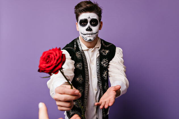 吉他情绪激动的家伙伸手去拿心爱的人画的是一个穿着墨西哥背心 手拿玫瑰 脸上涂满了颜料的人的肖像娱乐恐怖文化