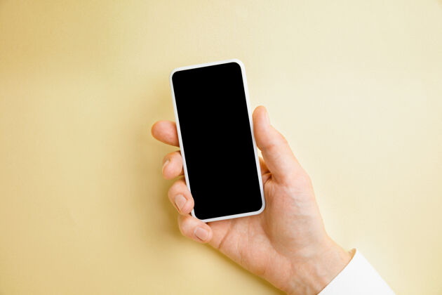 否定男性手持智能手机 黄色墙上有空白屏幕 用于文本或设计空白小工具模板 用于联系或在商务 金融 办公 采购中使用复制空间握住手指给予