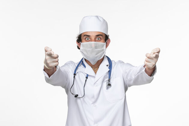 制服正面图男医生穿着医疗服 戴着无菌口罩 以防白墙病毒溅起冠状病毒大流行消毒病毒男人