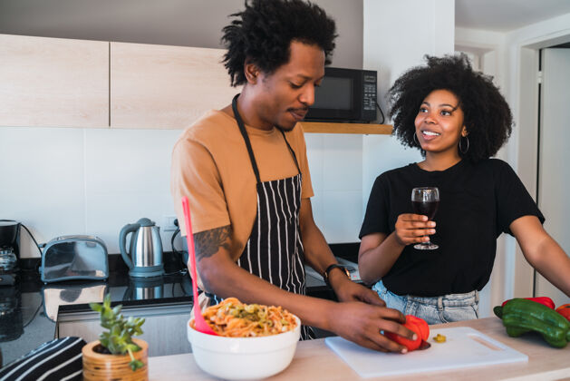 食物一对年轻的非洲夫妇在家里的厨房一起做饭的肖像关系 厨师和生活方式的概念烹饪非洲制作