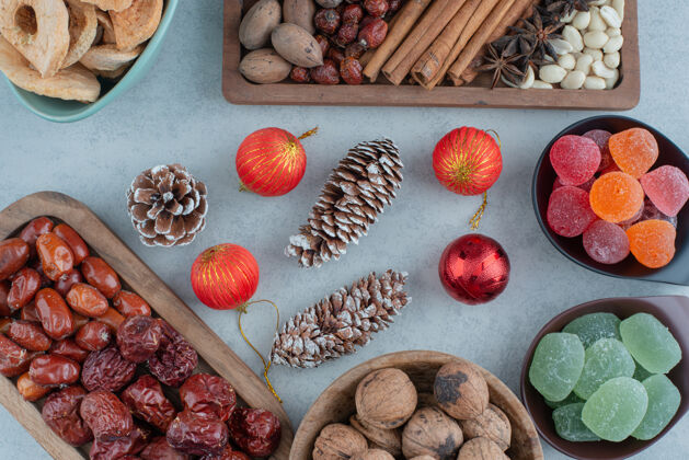 美味健康干果放在木制盘子里 配上圣诞玩具高品质照片松果圆锥体水果