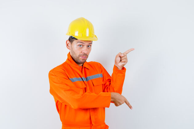 团队穿着制服的建筑工人 戴着头盔上下指指点点 神情犹豫不决 前视不定建筑商指手画脚承包商
