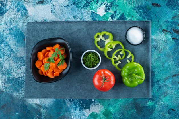 莳萝把胡萝卜片放在一个碗里 放在蔬菜旁边的蓝色毛巾上碗切片美味