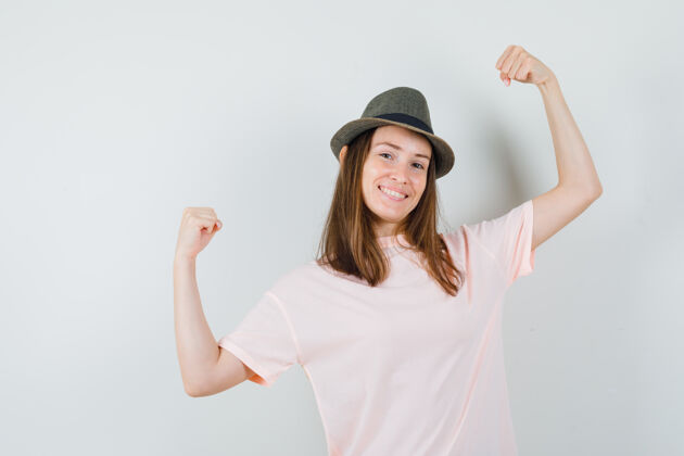快乐身穿粉色t恤 帽子的年轻女性 展现赢家的姿态 看起来很幸福 正面视图幸福女人积极