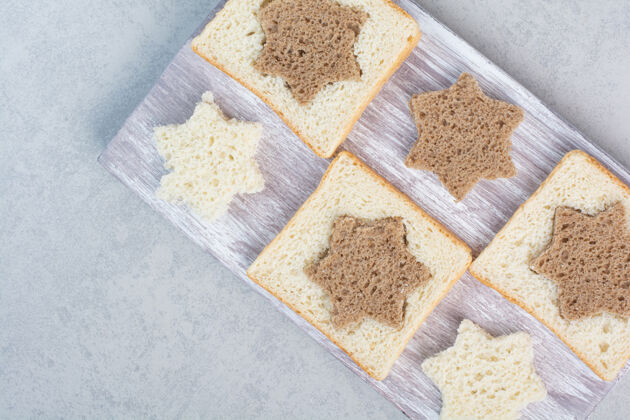 形状星形和方形的黑白面包片放在木盘上高质量的照片切片糕点星星