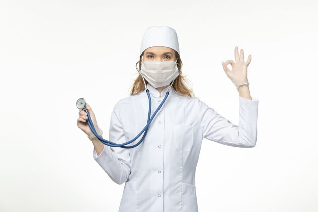 比赛前视女医生身穿医疗服戴口罩因冠状病毒手持听诊器白桌病毒大流行-冠状病毒病正面球员高尔夫球手