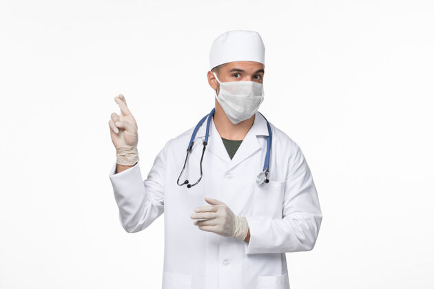 医生正面图：男医生穿着医疗服 戴着防冠状病毒口罩 上了淡白色的墙壁病毒冠状病毒-疾病大流行冠状病毒男性防护