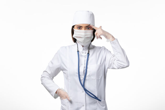 外套正面图女医生穿着白色医疗服 戴着口罩 因白墙上有冠状病毒病大流行病毒covid-疾病专业病毒
