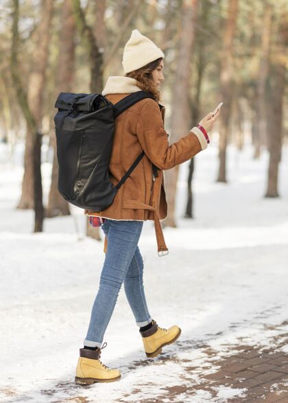 移动全镜头女人拿着手机走户外旅行森林
