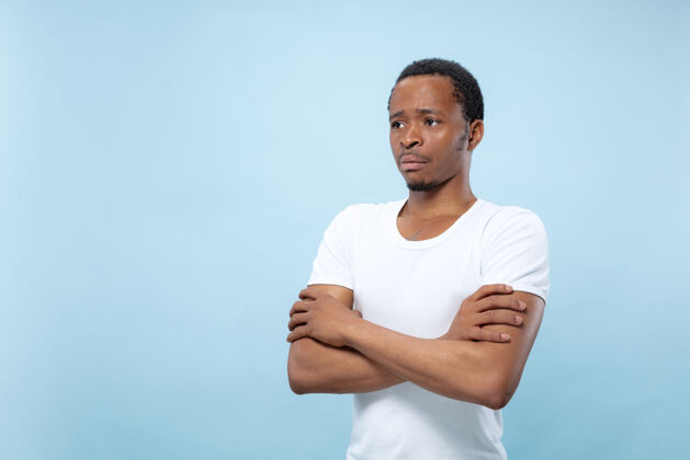 企业家半身特写肖像的年轻非洲裔美国人在白衬衫上的蓝色空间手交叉专业