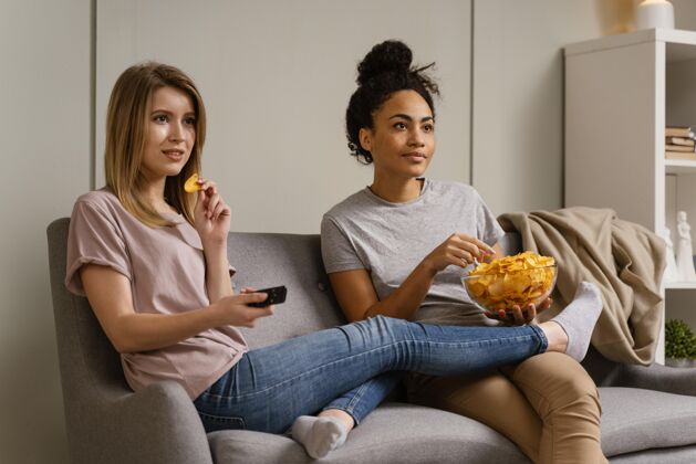 看电视坐在沙发上看电视吃薯片的女人房子室内女人