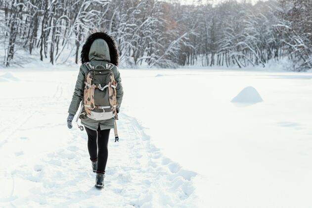 年轻冬天背着背包的女人场景雪冬天