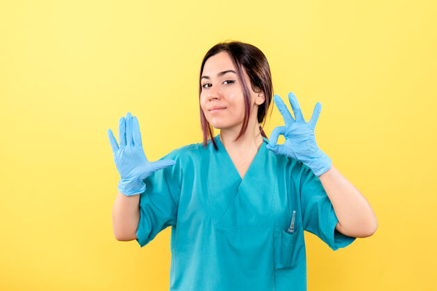 护士一位医生的侧视图是在谈论在病毒大流行期间戴上医用手套穿着谈话漂亮