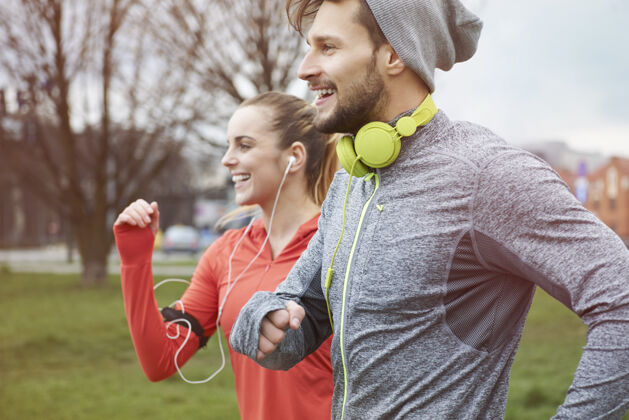 男人和女朋友慢跑时的内啡肽耳机运动锻炼
