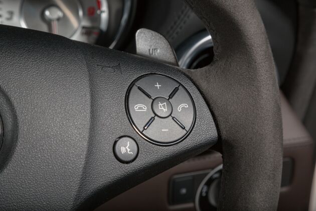 驾驶员现代汽车方向盘上的呼叫按钮特写镜头现代车轮形状