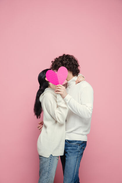 书桌在粉红色的工作室墙上 年轻美丽的情侣相爱了拥抱拥抱情人
